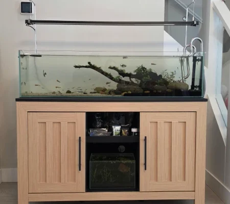 Aquarium stand wrapped in BODAQ W200 wood-look architectural film, replacing its original black appearance with a lighter, modern finish.