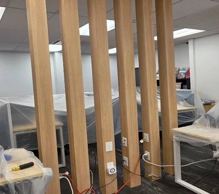 Six office posts wrapped in BODAQ SPW03 wood-look architectural film in a Richmond, BC office.